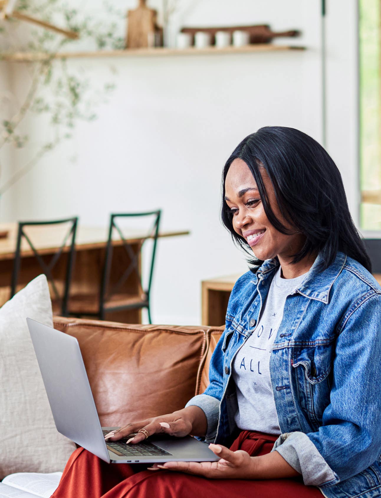 Woman seated, smiling, looking at Dayspring.com on laptop computer.